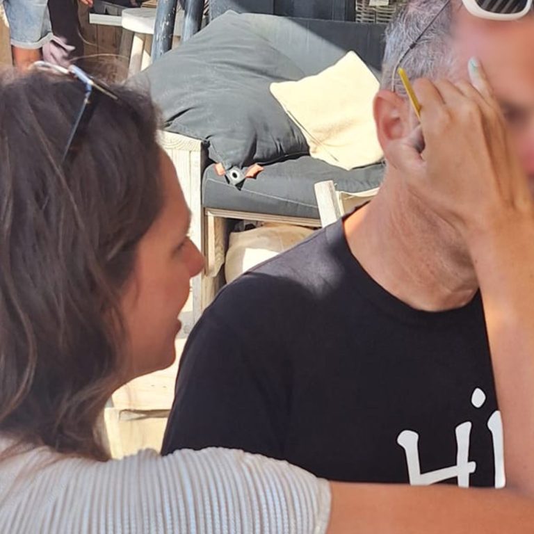 professionele face art op een festival creatiffany schminkend aan het werk op een festival